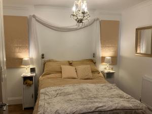 a bedroom with a bed with a chandelier above it at HomeForYou - Holiday Home in the Wolds in Spilsby
