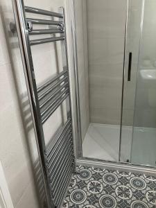 a shower with a glass door and a tile floor at HomeForYou - Holiday Home in the Wolds in Spilsby