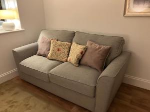 un sofá con 4 almohadas en una habitación en HomeForYou - Holiday Home in the Wolds en Spilsby