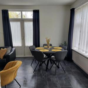 a dining room with a table and chairs at Hof Christina Vakantiewoningen in Vrouwenpolder
