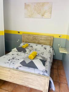 ein Schlafzimmer mit einem Bett mit zwei gelben Kissen darauf in der Unterkunft Chambres d'hôtes l'Orchidée Rose in Salazie