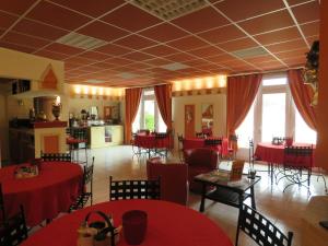 une salle à manger avec des tables, des chaises et une recherche de table rouge dans l'établissement LA CHINOISERIE, à Binson-et-Orquigny