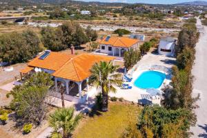 an aerial view of a house with an orange roof and a swimming pool at Villas Mina in Gennadi