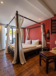 - une chambre avec un lit à baldaquin dans l'établissement Hotel Luina Beach, à Büsum