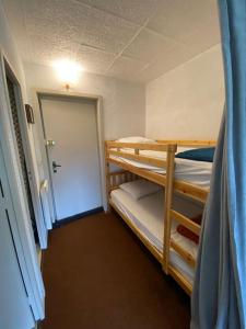 Pokój z 2 łóżkami piętrowymi i drzwiami w obiekcie Appartement 50m2 vue imprenable avec garage draps et serviettes compris w mieście Villard-de-Lans