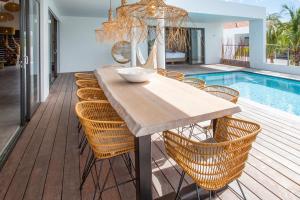 a dining table and chairs next to a pool at LXRY VILLA's in Jan Thiel