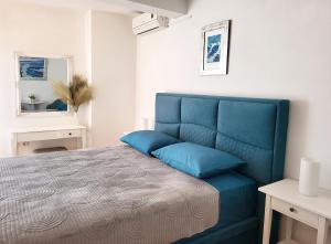 a blue bed in a white room with a blue couch at Villa Skalinada with sea view in Brela