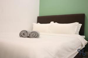 een wit bed met twee handdoeken erop bij Homesuite' Home at Sutera Avenue in Kota Kinabalu