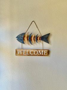 een welkomstbord met een vis aan de muur bij CasaCamilla in Piombino