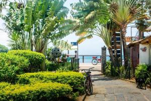 a bike parked on a sidewalk near the beach at Suite Ilha Grande in Angra dos Reis