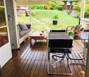 a screened in porch with a table and chairs at petite maison traditionnelle in Saint-Leu +4 photos