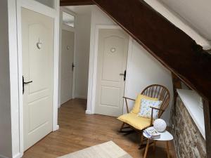 een zolderkamer met een stoel en witte deuren bij « La Belle Vie » Brittany, ideal for 2 to 6 people 