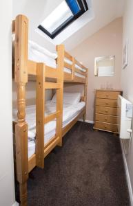 a bunk bed room with two bunk beds and a dresser at Tolroy Manor Holiday Park in Hayle