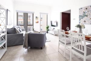 un soggiorno con divano, tavolo e sedie di Frank Porter - Canal Residence a Dubai