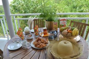 una mesa de madera con un plato de comida. en VILLA BAMBOU Domaine à l'ombre du Bambou jusqu'à 6 pers, Parc national de la Guadeloupe, en Le Gosier