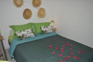 Un dormitorio con una cama con flores rosas. en VILLA BAMBOU Domaine à l'ombre du Bambou jusqu'à 6 pers, Parc national de la Guadeloupe, en Le Gosier