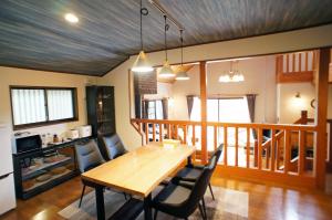 a dining room with a wooden table and chairs at HARUNA SKY Panoramic view of Nasu,private space surrounded by fir trees,relaxing stone bath,watching movies on a 120inch big screen in Nasu