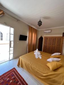 Un dormitorio con una gran cama amarilla con almohadas en Riad excellence luxe en Marrakech