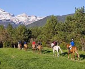 un grupo de personas montando caballos en un campo en Appartement de vacances en cerdagne, en Bourg-Madame