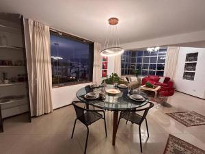 a dining room with a table and chairs in a living room at Amplio, cómodo y moderno apartamento cerca al Mall in Lima