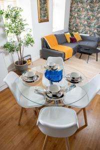 a living room with a glass table and white chairs at Modern & Spacious flat in the Centre of Bristol! in Bristol