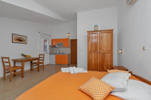 ein Schlafzimmer mit einem Bett und eine Küche mit einem Tisch in der Unterkunft Villa Juric in Baška Voda
