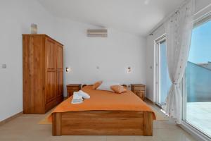 ein Schlafzimmer mit einem Bett und einem großen Fenster in der Unterkunft Villa Juric in Baška Voda