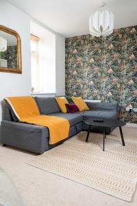a couch in a living room with a wall at Modern & Spacious flat in the Centre of Bristol! in Bristol
