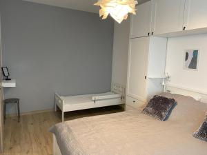 um quarto branco com uma cama e um banco em MINT&ROSE em Peroj