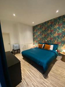 a bedroom with a blue bed and a large wall at “De Koelemert” in Aalst