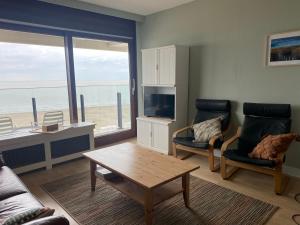 een woonkamer met een bank en een salontafel bij Zeezicht Blankenberge in Blankenberge