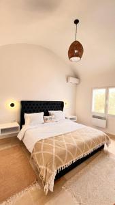 a bedroom with a large bed with a black headboard at Villa a la montagne Hammamet in Hammamet