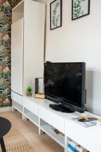 a living room with a television on a white entertainment center at Modern & Spacious flat in the Centre of Bristol! in Bristol