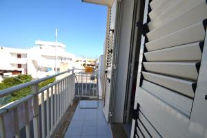 einen Balkon eines Hauses mit offener Tür in der Unterkunft Alba two-room air-conditioned holiday home for 4 guests in Torre dell'Orso