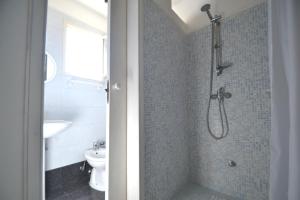 ein Badezimmer mit Dusche, Toilette und Waschbecken in der Unterkunft Alba two-room air-conditioned holiday home for 4 guests in Torre dell'Orso