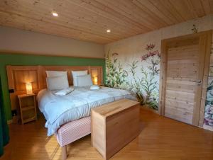 ein Schlafzimmer mit einem großen Bett und einer Holzdecke in der Unterkunft Maison Le ROZET in Les Gras