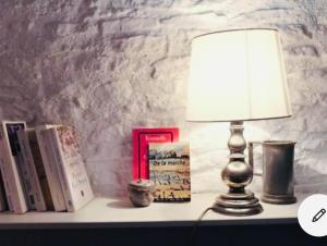 eine Lampe auf einem Tisch mit Büchern in der Unterkunft Maison centre historique Le Préau saint Jacques in Castres