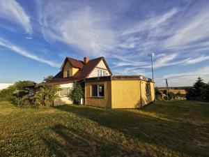 une maison sur un champ herbeux avec un ciel dans l'établissement Duży dom w malowniczym miejscu na Kociewiu, 