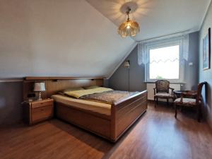 een slaapkamer met een bed en een kroonluchter bij Duży dom w malowniczym miejscu na Kociewiu 