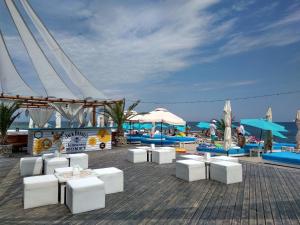 a deck with white chairs and umbrellas and the ocean at Smart Hostel in Odesa