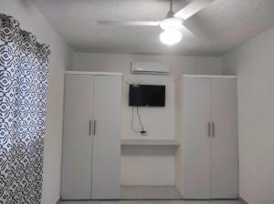 a living room with white cabinets and a flat screen tv at 100 Mts From Malecon Weeklymonthly Discount in Santa Bárbara de Samaná