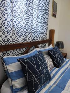a bedroom with a bed with blue and white pillows at 100 Mts From Malecon Weeklymonthly Discount in Santa Bárbara de Samaná