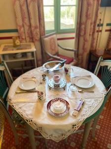 una mesa con platos y tazas encima en La Mascotte des thermes de Montbrun les bains, en Montbrun-les-Bains
