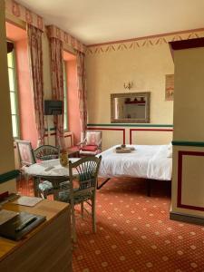 1 dormitorio con 1 cama, mesa y sillas en La Mascotte des thermes de Montbrun les bains, en Montbrun-les-Bains