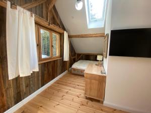 a small room with a tv and a bedroom at Das Hexenhaus: Haus im Wald in Rinchnach