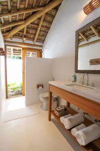 uma casa de banho com um lavatório e um WC em Pousada Outeiro em Praia do Espelho