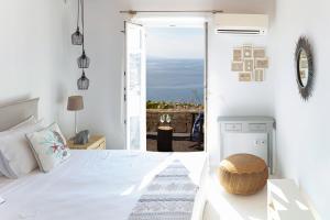 a bedroom with a bed with a view of the ocean at Villa Mandala in Mýkonos City
