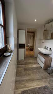 a bathroom with a white sink and a mirror at Rauschenbachmühle in Mildenau