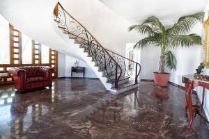 una escalera en una sala de estar con una palmera en La Ideal Mansion by VillaGranCanaria, en Tafira