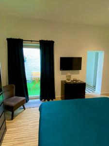 een slaapkamer met een bed, een televisie en een stoel bij “De Koelemert” in Aalst